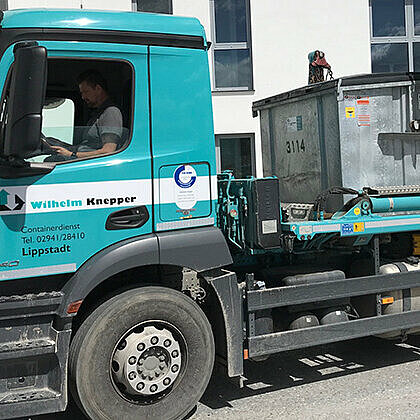 Ein LKW, der einen Absetzcontainer transportiert.